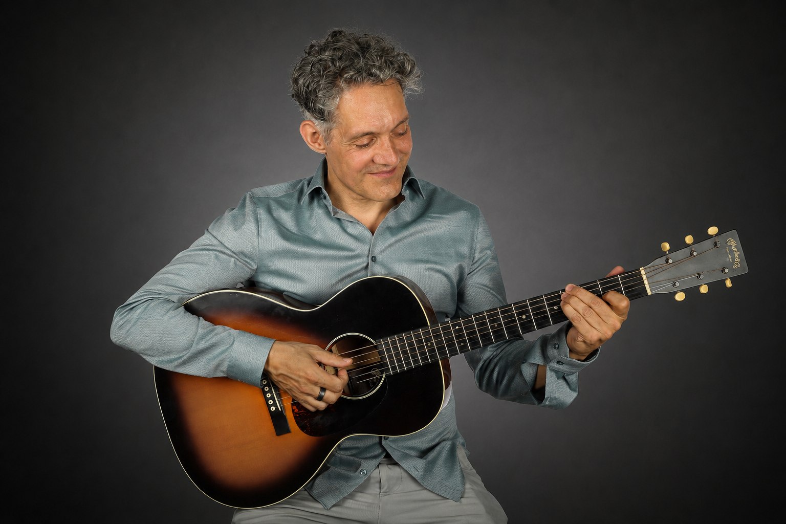 Stephan Bienwald schaut auf die Gitarre und spielt
